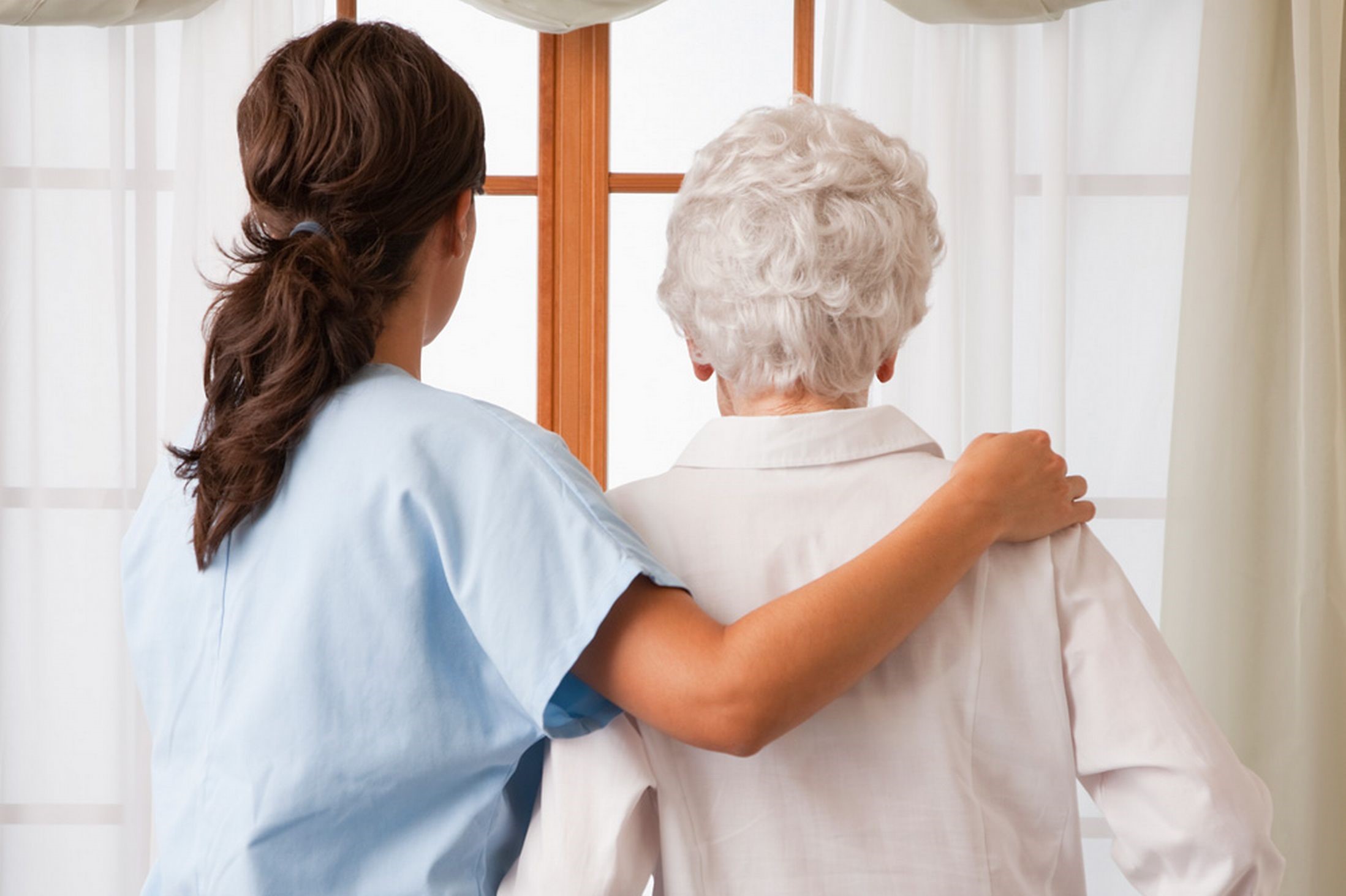 nurse escorting elderly woman